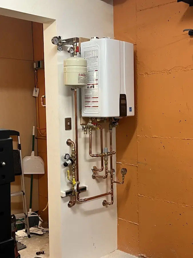Plumbing technician inspecting water heater connections in LaGrange